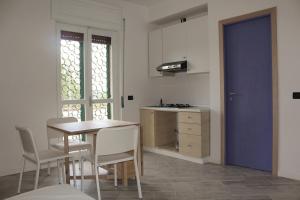 una cucina con tavolo e sedie e una porta blu di PioppiHouse a Pollica