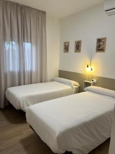 a hotel room with two beds and a window at Casa Rural Macondo in Trujillanos +21 photos
