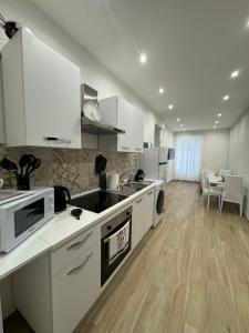 a kitchen with white appliances and a dining room at Dimora Appia in Rome