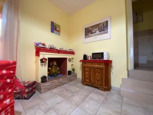 a living room with a fireplace with a christmas tree at La Petite Maison de Grand-Mére Assunta in Nola