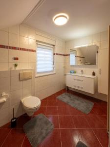a bathroom with a toilet and a sink at Ganzes Ferienhaus in Leipzig mit Garage und Fußbodenheizung in Leipzig