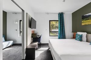 a hotel room with a bed and a mirror at Hôtel Restaurant AKENA Molinges - La Brocatelle in Saint-Claude