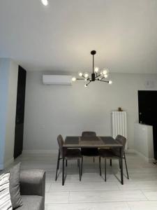 a dining room with a table and a chandelier at Tina's home in Batumi