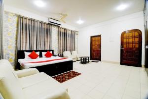 a bedroom with a bed and chairs in a room at Hotel O The Dove Villa in Dispur +30 photos