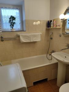 Un baño con bañera blanca y lavabo. en Apartament Praski 5 minut od metra i starego miasta spacerem do zoo i Konesera, en Varsovia