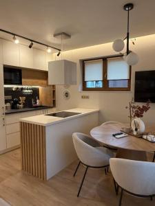 a kitchen with a table and a dining room at Cozy design 1 bedroom apartment in Bansko