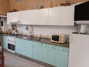 a kitchen with blue and white cabinets and a microwave at La Favorita in Pontevedra