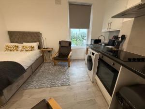 a small bedroom with a bed and a kitchen at Cosy Studio Central Colwyn Bay F2 in Colwyn Bay