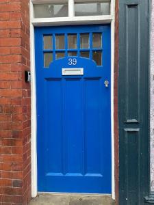 a blue door with the number on a brick building at Cosy Studio Central Colwyn Bay F2 in Colwyn Bay +10 photos