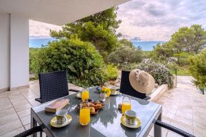 a table and chairs on a patio with a view at Apartment Milna - with Swimming Pool & Amazing Seaviews, above Bijaka Beach in Milna