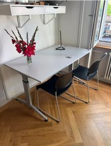 a white table with a vase of flowers on it at Winter in Bern