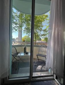 a sliding glass door with a table and a chair on a balcony at Winter in Bern