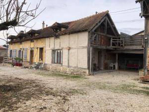 an old house with a roof on a dirt road at Petite maison paisible in Brillecourt