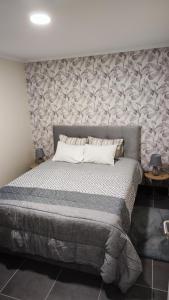 a bedroom with a large bed with a stone wall at Quinta' Home in Ribeira da Janela