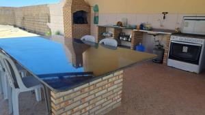 a kitchen with a counter top and a stove at Suítes Privativas à 100m da Praia "NÃO É CASA INTEIRA" in Beberibe