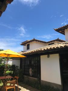 a house with an umbrella and a table and chairs at Praia de Geribá C 1 in Búzios