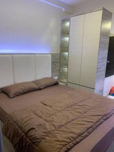 a bedroom with a large bed and a white cabinet at Comfortstay - Citra Plaza Nagoya #31-08 Sea View in Jodoh