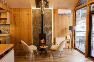 a living room with a fireplace and white chairs at Цекіт in Yaremche
