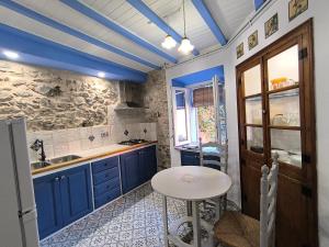 a kitchen with blue cabinets and a small table at Ca LA LIDIA GARRIGUELLA in Garriguella