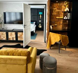 a living room with a couch and a television at Die Altstadt Appartements Caprice in Goslar