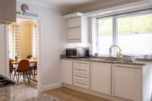 a kitchen with a sink and a microwave at Rooftops - Sea Views Hot Tub Close to Beach in Saundersfoot