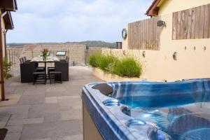a swimming pool on a patio with a table at Rooftops - Sea Views Hot Tub Close to Beach in Saundersfoot