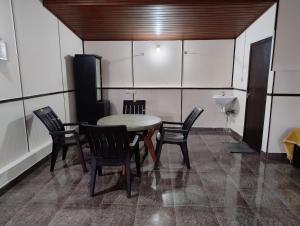 a dining room with a table and chairs and a sink at Verdant Hillock in Wayanad