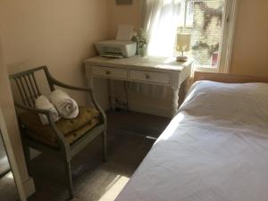 a bedroom with a bed and a desk and a chair at Victorian Period Central Home in Cambridge +10 photos
