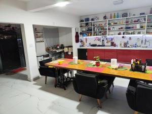 a kitchen with a large wooden table and chairs at 11Suites casa Suite #7 in Caraguatatuba