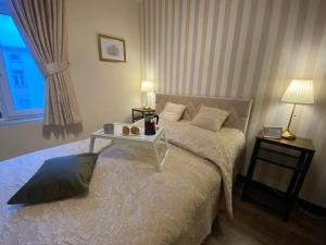 a bedroom with a bed with a table on it at Polonia Apartments No-68 Near Piotrkowska in Łódź