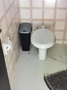 a bathroom with a toilet and a trash can at 11Suites casa Suite #7 in Caraguatatuba +6 photos