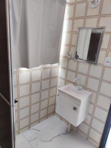 a bathroom with a sink and a mirror at 11Suites casa Suite #7 in Caraguatatuba