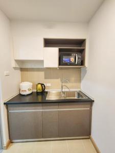 a kitchen with a sink and a microwave at Lily's City Apartment - Phasi chareon Station in Bangkok