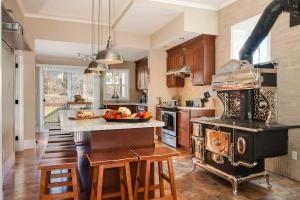 a kitchen with an old stove and some chairs in it at Gîte Les Pignons in Saint-Damien