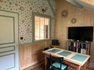 a room with a table and a tv and a window at Nature et Découvertes 1 ch in Sirod
