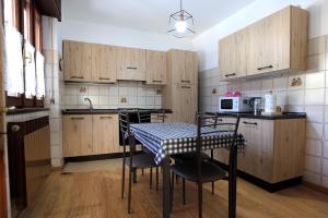 コーレレにあるCasa Valentinaの木製のキャビネットとテーブルと椅子を備えたキッチン +9枚の写真