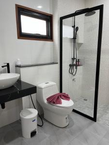 a bathroom with a shower and a toilet and a sink at Pinky Bungalow Resort & Villa - SHA Extra Plus in Ko Lanta