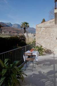 een tafel en stoelen op een balkon met bergen op de achtergrond bij Ca La Remei i Can Benet in Els Hostalets d'en Bas