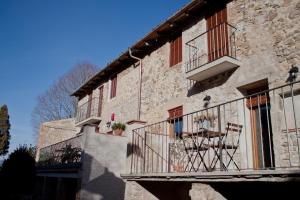 a building with a balcony and a table on it at Ca La Remei i Can Benet in Els Hostalets d'en Bas