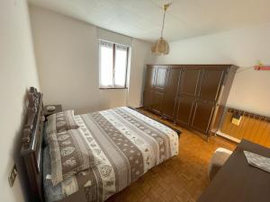 コーレレにあるCasa Valentinaのベッドと木製のキャビネットのある寝室