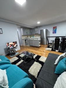 a living room with a blue couch and a kitchen at M&G centar grada in Požarevac