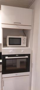 a microwave sitting on top of a kitchen oven at Venos Home 2 in Lemvig