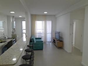 a living room with a green couch and a kitchen at Apartamento Vista Mar atalaia varanda gourmet in Aracaju