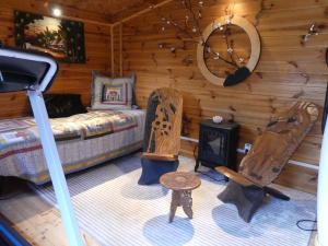 VaragesAu Cabanon Chez Nath - chbre d'hôtes的小木屋内一间卧室,配有一张床和椅子