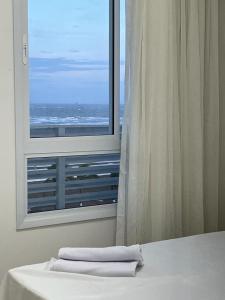 two towels sitting on a bed in front of a window at Apartamento Vista Mar atalaia varanda gourmet in Aracaju +32 photos