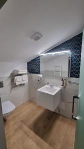 a bathroom with a white sink and a toilet at Heritage Boutique in Caracal