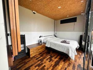 a bedroom with a bed and a wooden floor at Cabana Black BIRD l, morro da igreja Urubici SC in Urubici