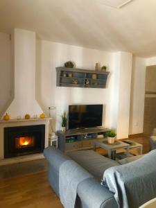 a living room with a couch and a fire place at Alojamiento La Fuente in Fuenteheridos