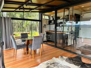 a kitchen and dining room with a table and chairs at Cabana Black BIRD l, morro da igreja Urubici SC in Urubici