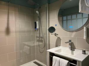 a bathroom with a shower and a sink at Hôtel Le Normandy - Maison Tassoni in Vernon